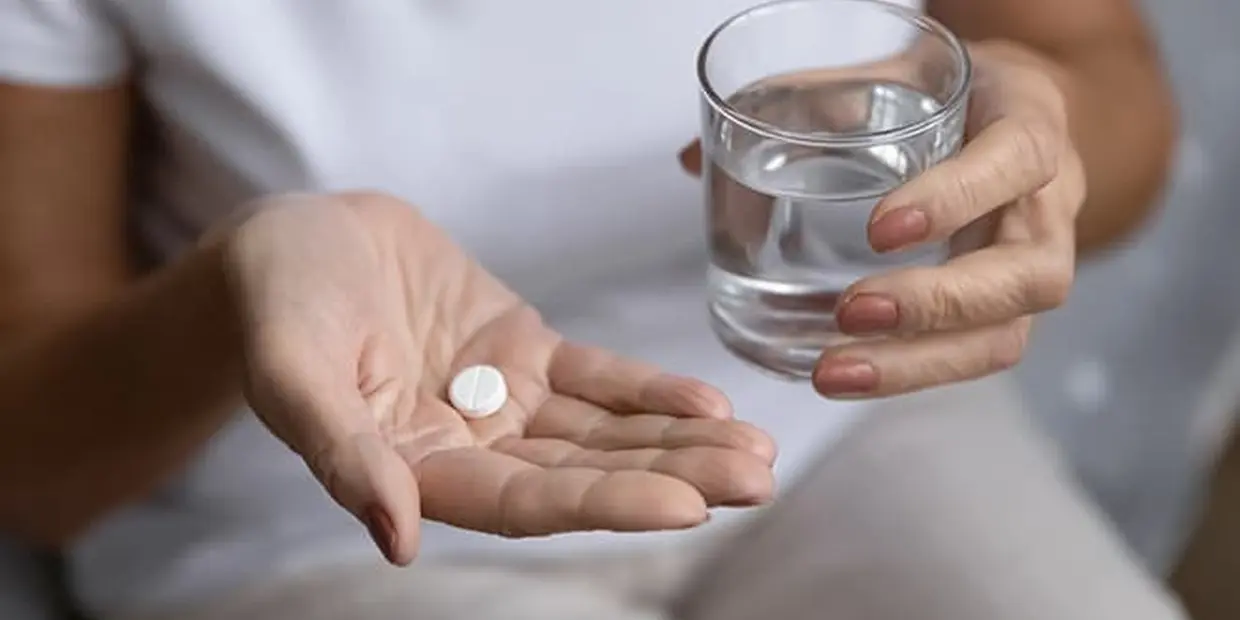 woman taking Suboxone prescription with a glass of water