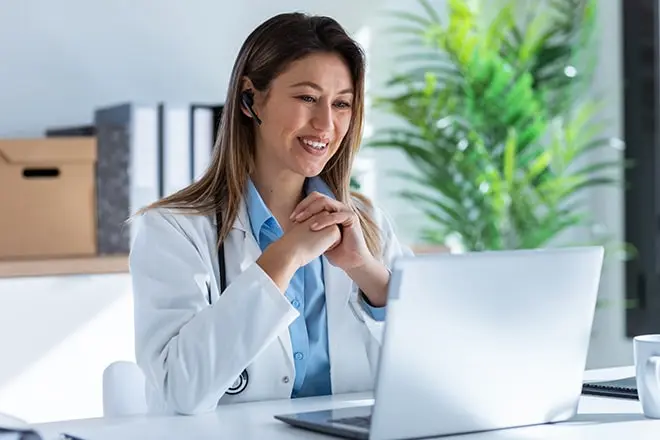 A doctor providing addiction treatment to a patient over a telehealth video call.